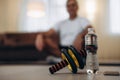 Take care of your body Close up sports equipment. Exercise Wheel. Plastic water bottle. Blurred man in easy seat pose Royalty Free Stock Photo