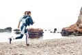 Take care of your body. Side view of strong disabled woman in sportswear with prosthetic leg is running on the beach. Royalty Free Stock Photo