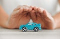 Take care of your car. a unrecognizable female covering a toy car with his hands at home. Royalty Free Stock Photo