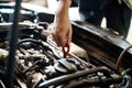 Take care of your car and your car will take care of you. a mechanic pulling out the dipstick to check a cars oil level. Royalty Free Stock Photo