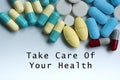 Take care of your health text on medical table with pills, tablets and capsules Royalty Free Stock Photo