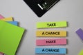 Take a Chance Make a Change text on sticky notes with office desk concept