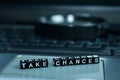 Take Chances text wooden blocks in laptop background. Business and technology concept Royalty Free Stock Photo