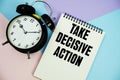 Take Decisive Action text written on notepad with alarm clock flat lay on multicolor pastel background Royalty Free Stock Photo