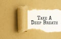 take a deep breath text, text on white paper on torn paper background Royalty Free Stock Photo