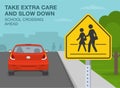 Take extra care and slow down, school crossing ahead. Red car is reaching the school zone. Royalty Free Stock Photo