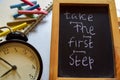 Take the first step phrase colorful handwritten on chalkboard, alarm clock with motivation and education concepts. Royalty Free Stock Photo