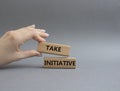 Take initiative symbol. Wooden blocks with words Take initiative. Beautiful grey background. Businessman hand. Business and Take