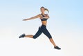 Take a leap towards fitness. Full length shot of a sporty young woman jumping against a blue sky. Royalty Free Stock Photo