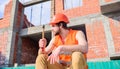 Take minute to relax. Man hammer take break working day at construction site. Builder vest and helmet construction site