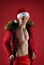 Take off winter jacket. Healthy body. Santa claus diet. Athlete man wear santa hat. Sexy athletic macho in santa claus