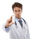 Take one a day without exception. Studio shot of a serious-looking young doctor holding a pill bottle up to the camera. Royalty Free Stock Photo