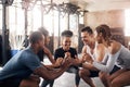Take it one squat at a time. a group of young people doing squats together during their workout in a gym. Royalty Free Stock Photo