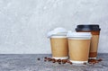 Take-out blank paper brown coffee cups with black and white covers, craft cup holders and beans Royalty Free Stock Photo