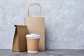 Take-out blank paper coffee cup with white cover, craft cup holder and brown packets Royalty Free Stock Photo