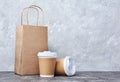 Take-out blank paper coffee cups with white covers, craft cup holders and brown packet Royalty Free Stock Photo