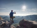 Take phone photo. Hiker sit at edge for taking selfie picture