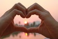 Take photo hands together to form a heart and light from the sun in morning. This photo contain noise and burry Royalty Free Stock Photo