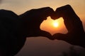 Take photo hands together to form a heart and light from sun in morning