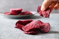 Take a piece vegetable beetroot chips on a gray background.