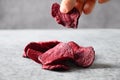 Take a piece vegetable beetroot chips on a gray background.