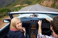 Take the road less travelled...A young couple taking a road trip in a convertible. Royalty Free Stock Photo