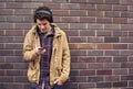 Take a sad song and make it better. a young man standing outdoors listening to music from his cellphone. Royalty Free Stock Photo