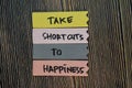 Take Shortcuts to Happiness write on sticky notes isolated on Wooden Table. Motivation or Insipiration Concept