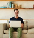 Take some time to check out my blog. Portrait of a handsome young man using his laptop while sitting on the sofa at home Royalty Free Stock Photo