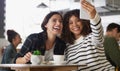 We take such great pics together. two young women taking selfies together in a cafe. Royalty Free Stock Photo