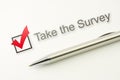 Take survey check box with a pen on paper background