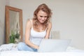 Take time to chill. Young happy woman using a laptop and having fun on the sofa at home Royalty Free Stock Photo