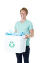 Take the time to recycle. A happy young red-headed man holding a recycling bin filled with empty plastic bottles. Royalty Free Stock Photo