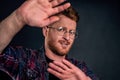 Take this ugly thing away from me. Displeased intense redhead mature guy in glasses and checkered shirt, turning away Royalty Free Stock Photo