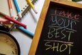 Take your best shot on phrase colorful handwritten on chalkboard, alarm clock with motivation and education concepts.