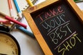 Take your best shot on phrase colorful handwritten on chalkboard, alarm clock with motivation and education concepts.