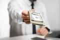 Take your money! Portrait of richman investor big boss in white shirt and black tie are sitting in office giving your a lot of Royalty Free Stock Photo