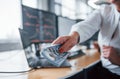 Take your salary. Close up view of woman`s hands that holds money near the monitors with graphs Royalty Free Stock Photo