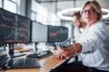 Take your salary. Close up view of woman`s hands that holds money near the monitors with graphs Royalty Free Stock Photo