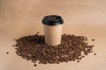 Takeaway brown paper coffee cup with black cap stands on roasted beans at brown background. Mock up Royalty Free Stock Photo