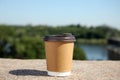 Takeaway cardboard coffee cup with plastic lid on stone surface outdoors Royalty Free Stock Photo