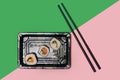 Takeaway flat lay sushi concept. Three sushi with salmon, squid, tuna fish, rice, cucumber carrots and nori seaweed rolls in a