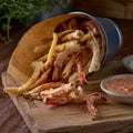 Takeaway food. french fries and vegetables in batter, carrots, sweet peppers, cured and sauces on a wooden board Royalty Free Stock Photo