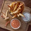 Takeaway food. french fries and vegetables in batter, carrots, sweet peppers, cured and sauces on a wooden board Royalty Free Stock Photo