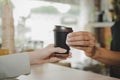 Takeaway. hand friendly barista serving black hot coffee cup to female customer over counter in modern cafe coffee shop Royalty Free Stock Photo