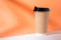 Takeaway paper coffee cup mockup with shadow on orange background