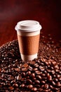 Takeaway paper cup of coffee with coffee beans