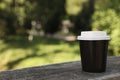 Takeaway paper cup with plastic lid on stone parapet outdoors, space for text Royalty Free Stock Photo