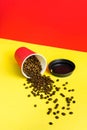 Takeaway red paper coffee cup with black cap on red and yellow background with pouring roasted beans Royalty Free Stock Photo