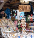 A female sells souvenirs and other trinkets to tourists from a stall in the middle of Prague